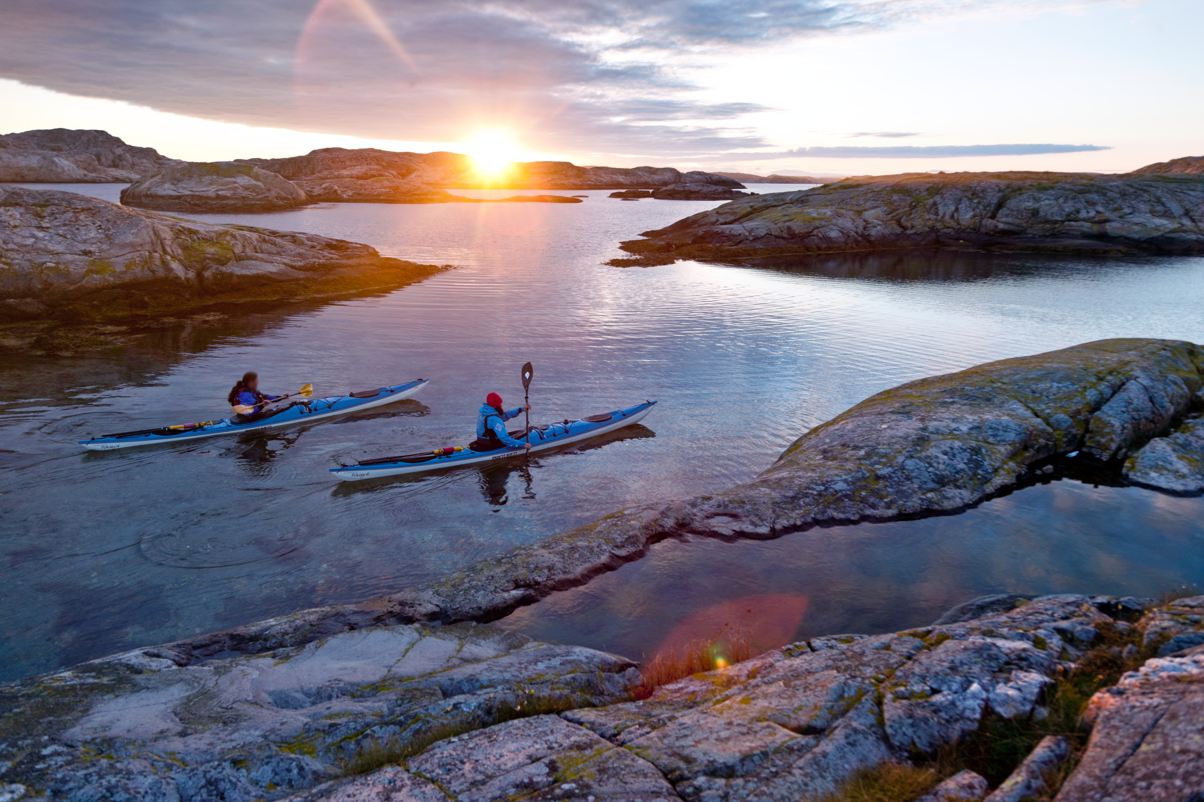 View of artipelag with two kayaks paddeling in sunset. Image.