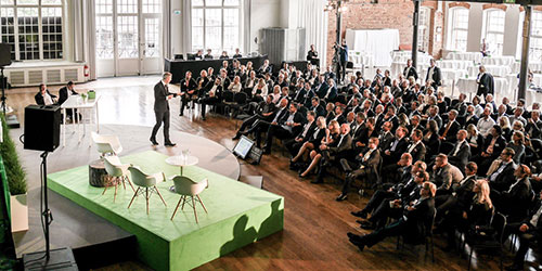 Stage and audience inside a large room. Photo.